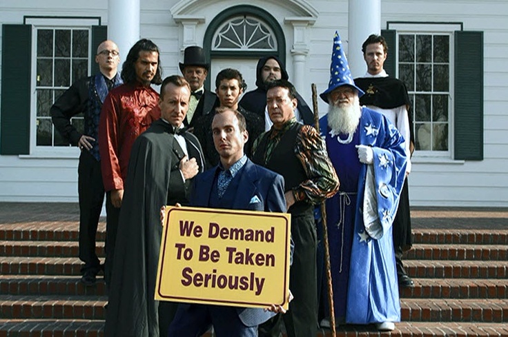 Picture of the iconic Arrested Development scene in which an assembled group of magicians brandish a sign which reads 'we demand to be taken seriously' on the steps of a government building.